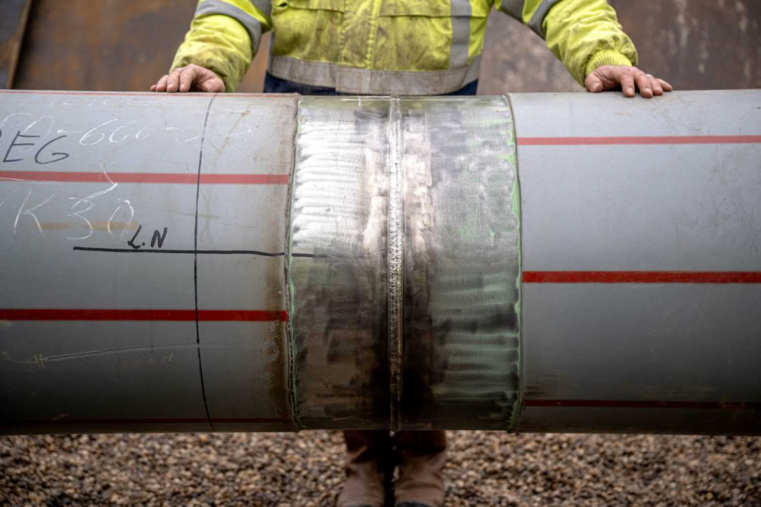 Workers inspect the last weld seam of another connecting pipeline for the LNG terminal in Wilhelmshaven.