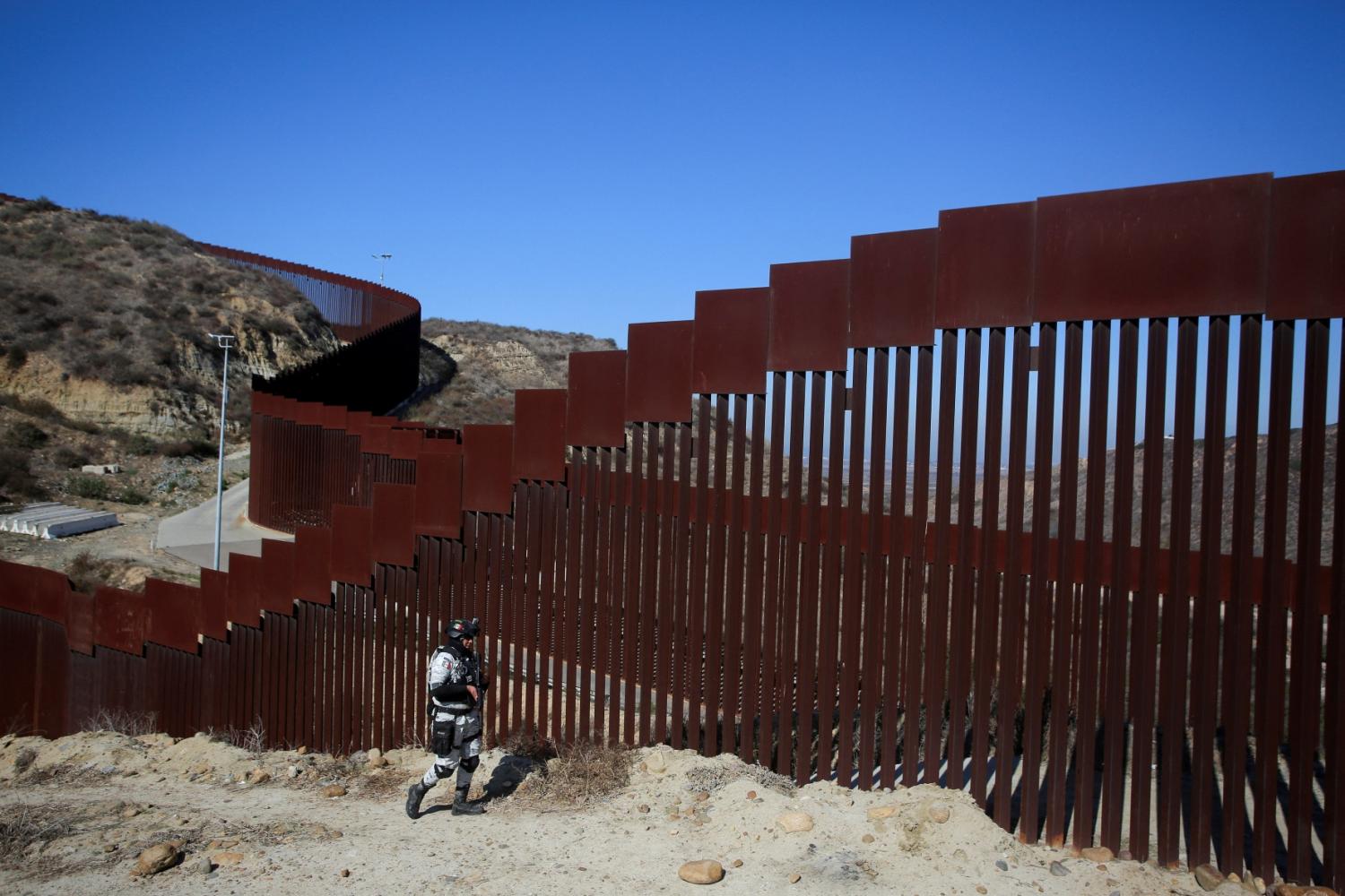 A member of Mexico's National Guard patrols the border wall between Mexico and the U.S. after Mexican President Claudia Sheinbaum agreed with U.S. President Donald Trump to bolster border enforcement efforts in response to Trump's demand to crack down on immigration and drug smuggling, in Tijuana, Mexico February 5, 2025.