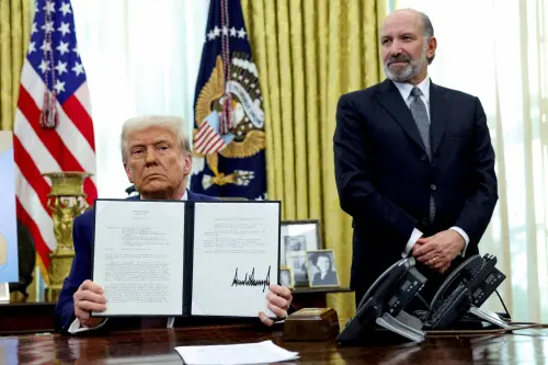 U.S. President Donald Trump holds an executive order about tariffs increase, flanked by U.S. Commerce Secretary Howard Lutnick, in the Oval Office of the White House in Washington, D.C., U.S., on February 13, 2025. REUTERS/File Photo