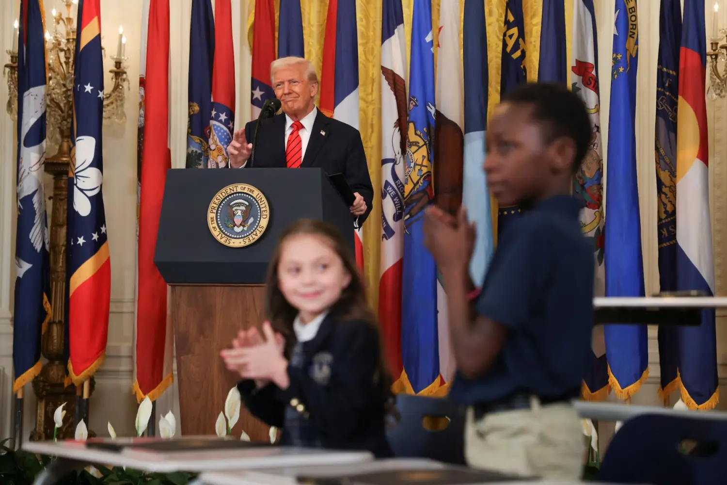 Children applaud as U.S. President Donald Trump attends an event to sign an executive order to shut down the Department of Education, in the East Room at the White House in Washington, D.C., U.S., March 20, 2025.