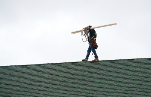 A construction worker on a roof representing work permits