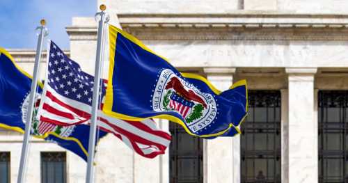 Washington, US, March 2023: flags of the Federal Reserve and the United States waving with the Eccles Building in the background.