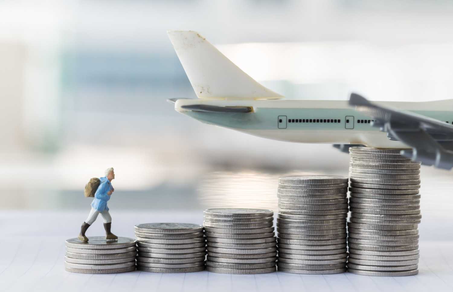 Figure walking on stacks of coins toward a plane.