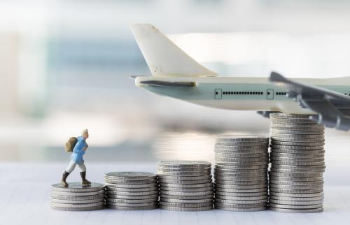 Figure walking on stacks of coins toward a plane.
