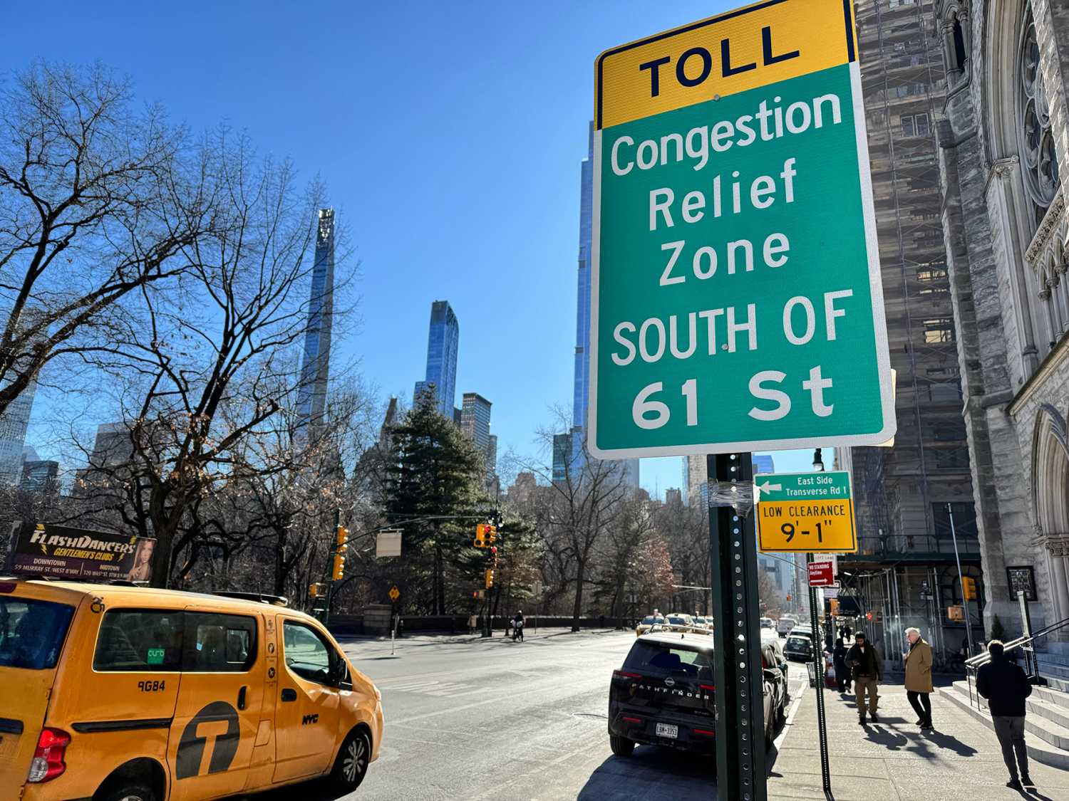 New York, NY USA - January 28, 2025 : Taxi driving down Central Park West next to a "Toll: Congestion relief zone south of 61 Street" sign on the Upper West Side of Manhattan, New York City