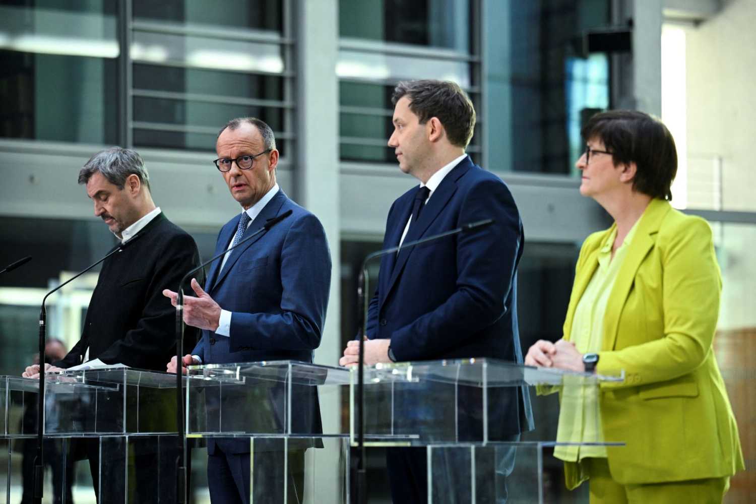 Four people standing behind podiums