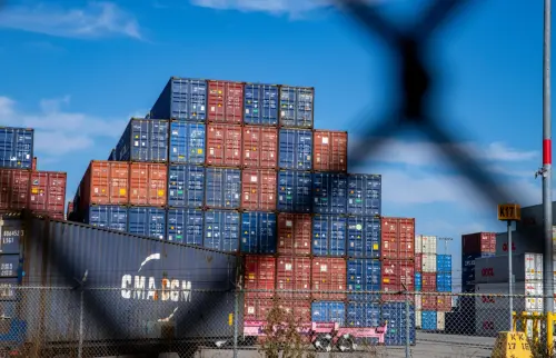 Shipping containers through a chainlink fence.