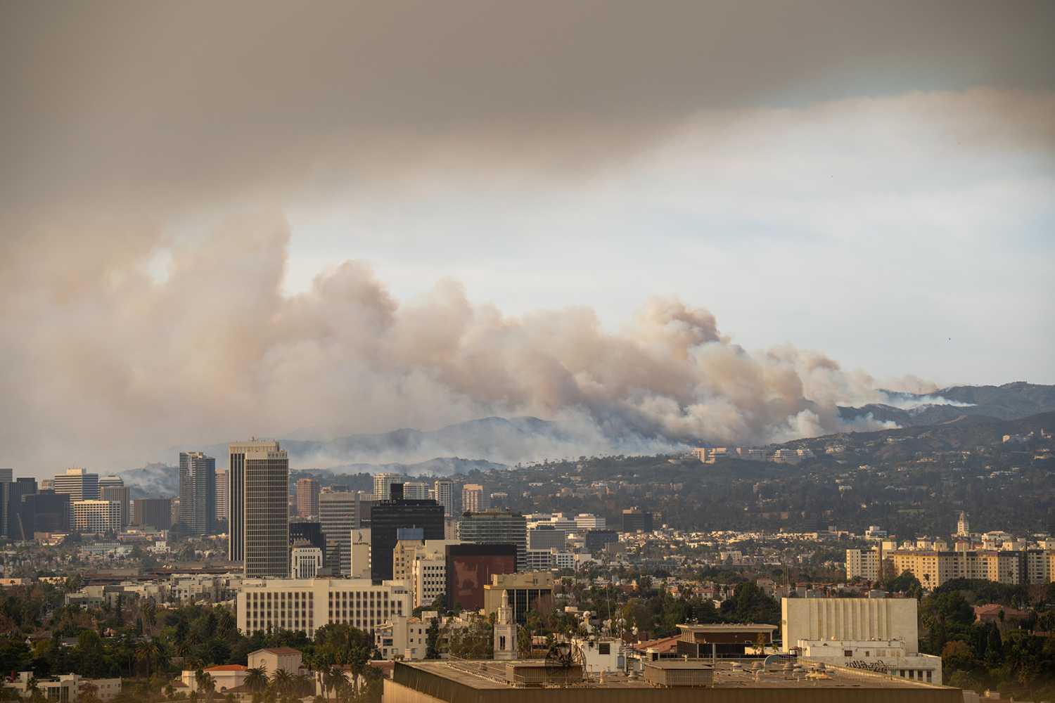 Wildfire in Pacific Palisades, Los Angeles, January 8, 2025, towards Getty Center and Brentwood. Images showcase dense smoke clouds, burning hillsides, and urban areas at risk.