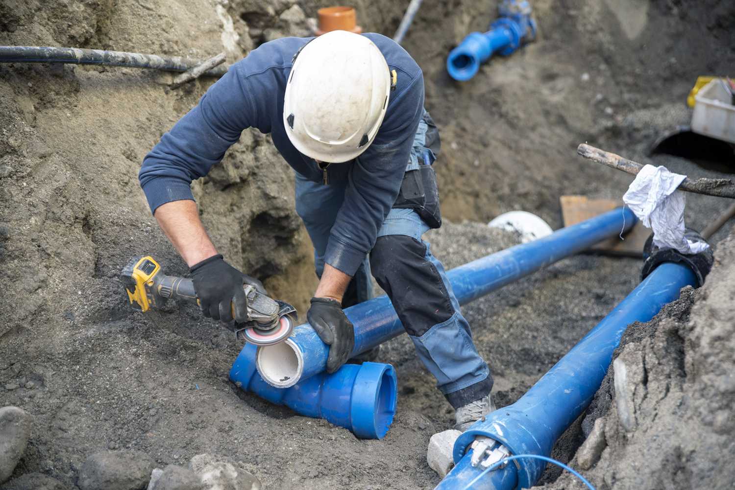 Workers install underground pipes for water, sewerage, electricity and fiber optics for the population of an urban center.