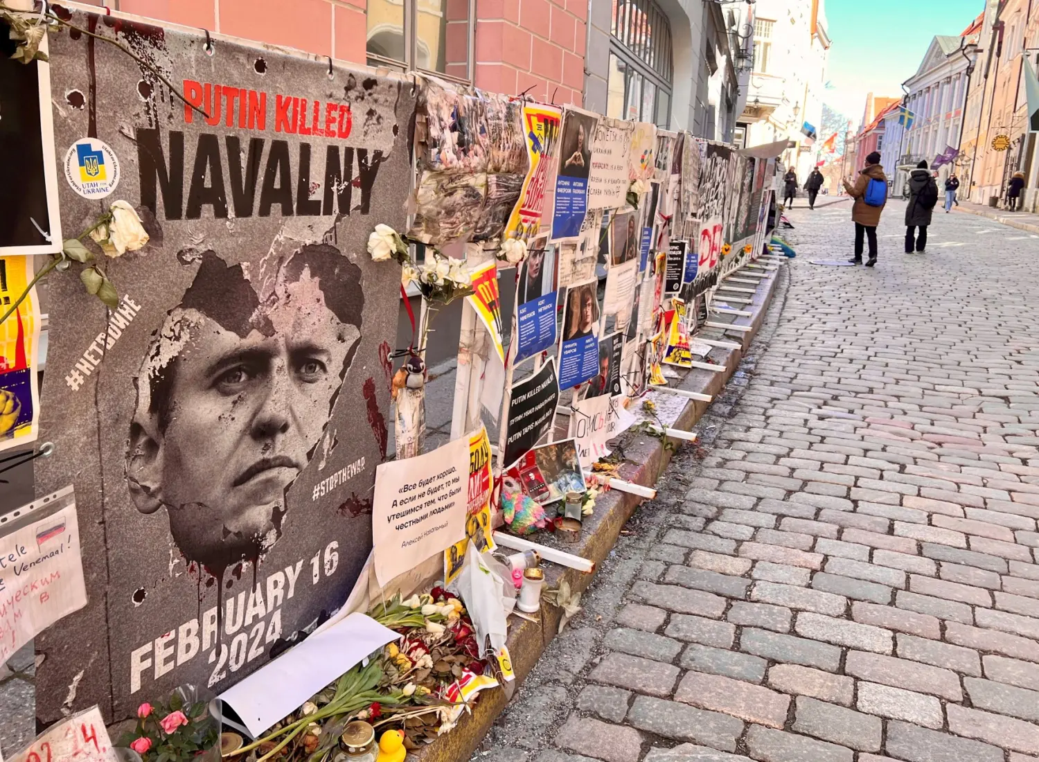 People walk past anti-Putin posters and other items which were left in protest outside the Russian Embassy, amid Russia's attack on Ukraine, in Tallinn, Estonia, March 22, 2025.