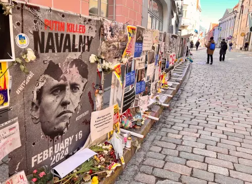 People walk past anti-Putin posters and other items which were left in protest outside the Russian Embassy, amid Russia's attack on Ukraine, in Tallinn, Estonia, March 22, 2025.