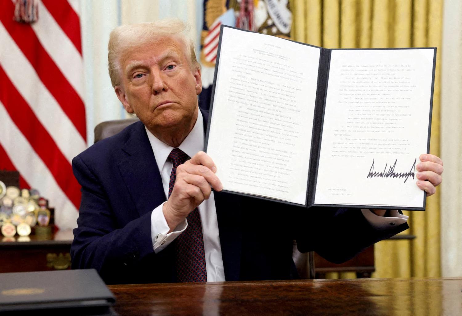 U.S. President Donald Trump holds a signed executive order on cryptocurrencies, in the Oval Office of the White House, in Washington, U.S., on January 23, 2025.