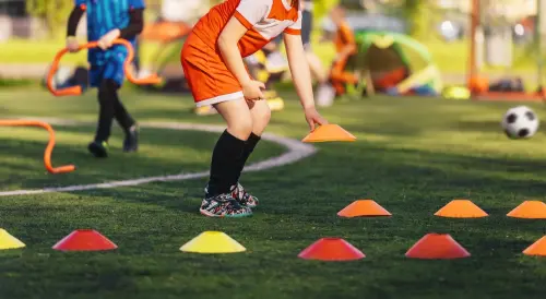 Kids playing soccer on a field.