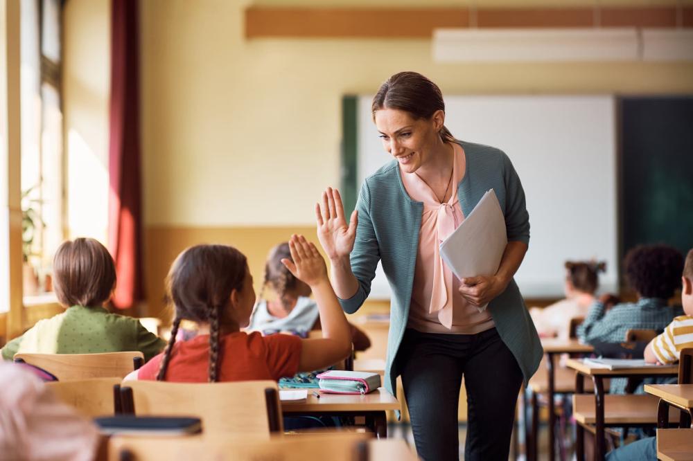 Student is shown high-fiving her teacher