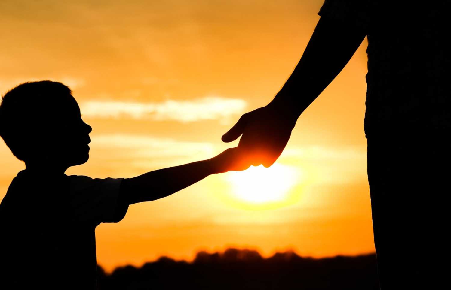 a father and son silhouetted in a sunset