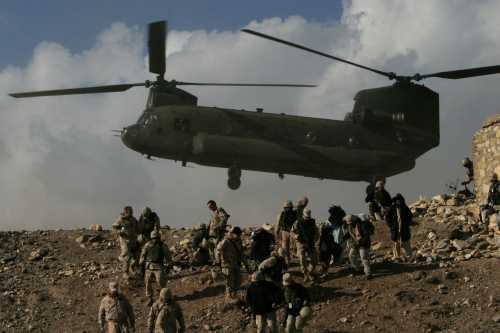 A Chinook helicopter hovers over U.S. troops in Afghanistan.