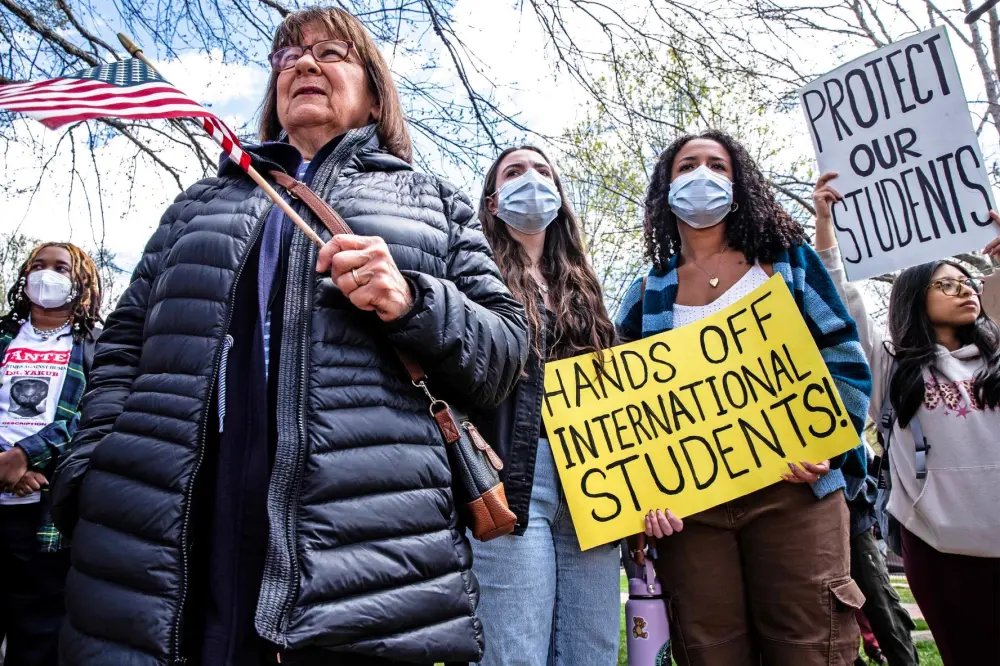 University of Delaware students and others rally to support at least eight UD students whose visas were revoked on the sidewalk in front of Old College in Newark on April 16, 2025.