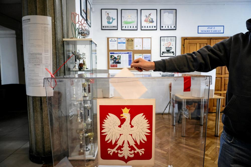 A person votes during the first round of Poland's presidential election at a polling station in Krakow, Poland, May 18, 2025.