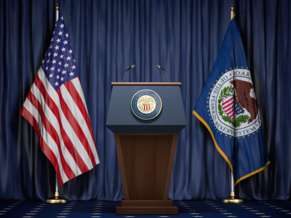 Federal-Reserve-System-Fed-of-USA-chairman-press-conference-concept.-Tribune-with-symbol-and-flag-of-FRS-and-United-States