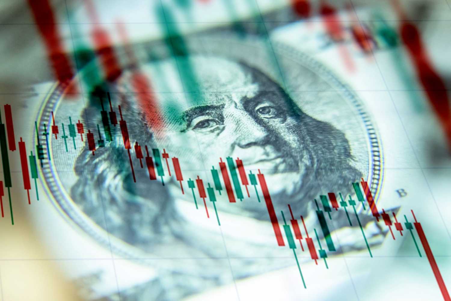 A chart showing falling values, laid on top of Benjamin Franklin's portrait on the $100 bill