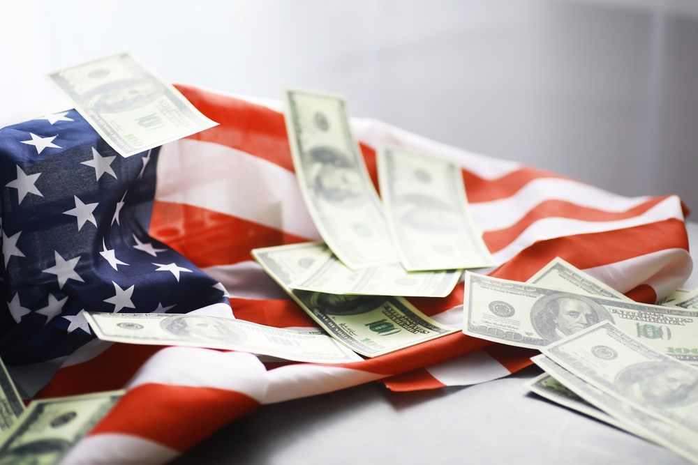 $100 bills on a crumpled American flag.