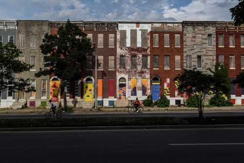Young boys ride their bikes past boarded-up and abandoned row of houses in Baltimore, Maryland, U.S., May 26, 2019.