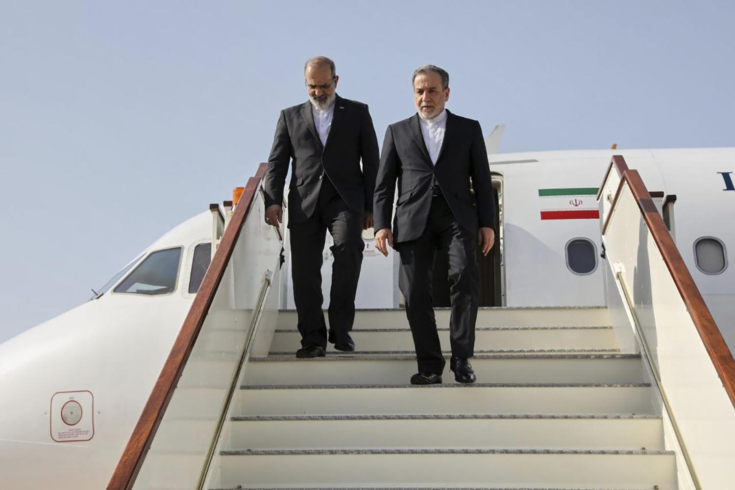 In this photo released by Iranian Foreign Ministry, Iranian Foreign Minister Abbas Araghchi, right, steps out from his plane as he arrives at Muscat, Oman, Friday, April 25, 2025, a day prior to negotiations with U.S. Mideast envoy Steve Witkoff.