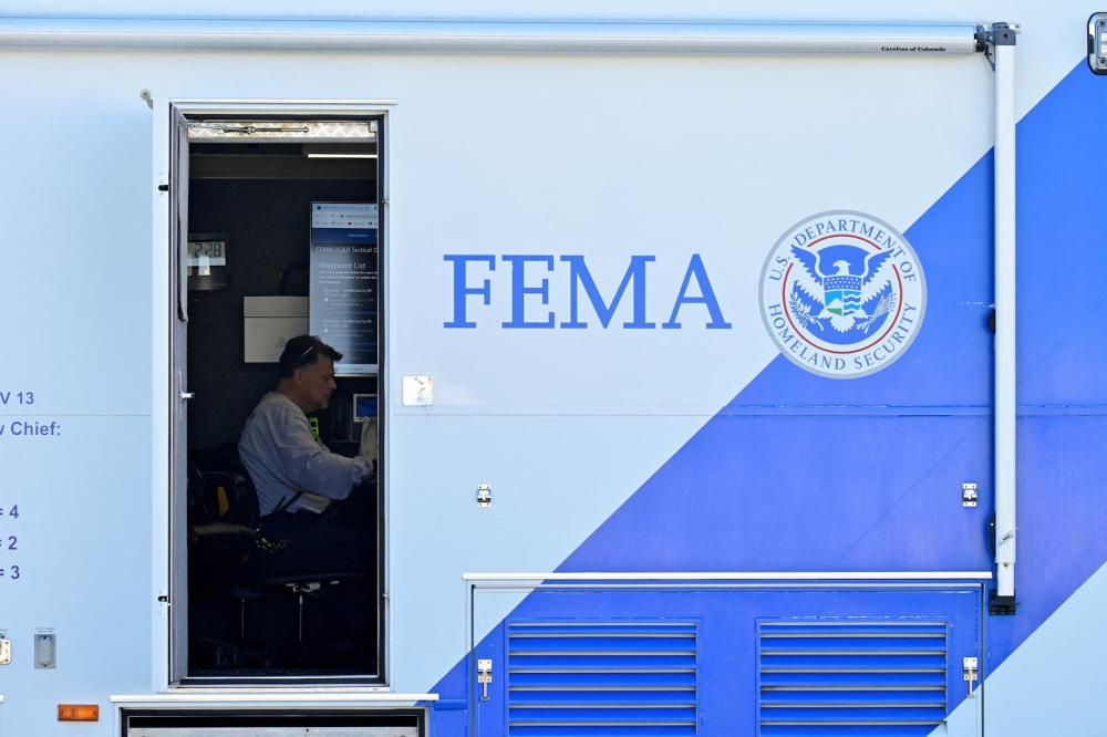A person sits at a desk inside of a mobile FEMA command center after tornadoes ripped through several U.S. states in downtown Dawson Springs, Kentucky, U.S., on December 14, 2021.
