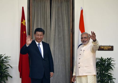 India's Prime Minister Narendra Modi (R) and China's President Xi Jinping wave to the media during a photo opportunity ahead of their meeting at Hyderabad House in New Delhi September 18, 2014.