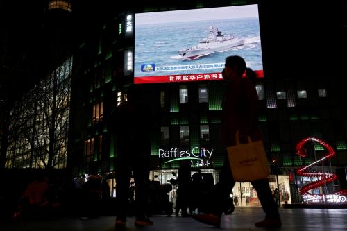 A Chinese navy vessel is seen on a giant screen showing news footage about joint army, navy, air and rocket forces drills around Taiwan by the Chinese People's Liberation Army (PLA), outside a shopping mall in Beijing, China, April 1, 2025.