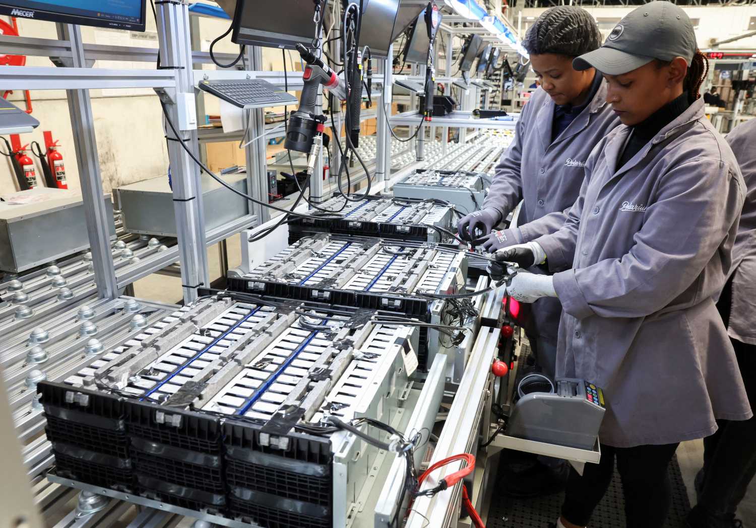 Workers at an energy-storage facility built on lithium-ion battery technology, in Cape Town, South Africa, April 5, 2023. REUTERS/Esa Alexander
