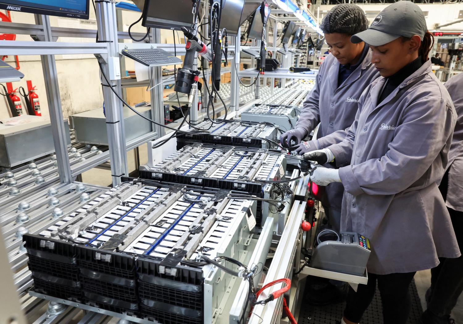 Workers at an energy-storage facility built on lithium-ion battery technology, in Cape Town, South Africa, April 5, 2023. REUTERS/Esa Alexander