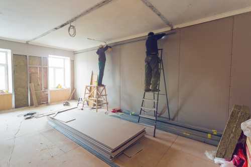 Workers are installing plasterboard (drywall) for gypsum walls in apartment is under construction, remodeling, renovation, extension, restoration and reconstruction.