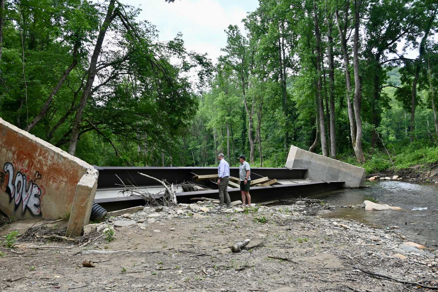Tony Pipa and Jason McDougald inspect the damaged bridge in Old Fort, North Carolina, June 2025. (Photo by Molly Born)