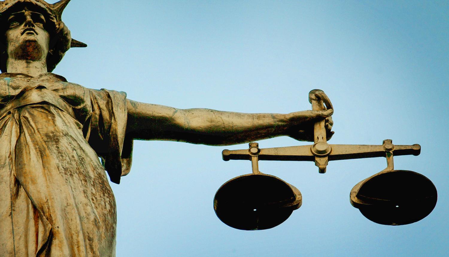 A statue holding the scales of justice is seen on top of the Old Bailey in London, on December 12, 2003.