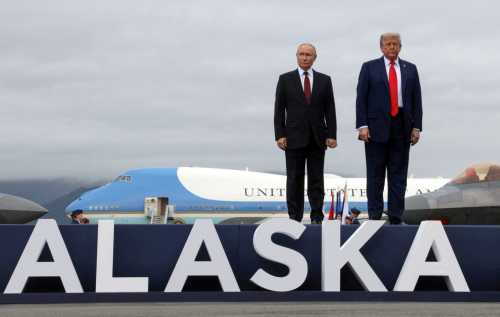 Russian President Vladimir Putin and U.S. President Donald Trump pose on a podium on the tarmac after they arrived to attend a meeting at Joint Base Elmendorf-Richardson in Anchorage, Alaska, U.S., August 15, 2025.