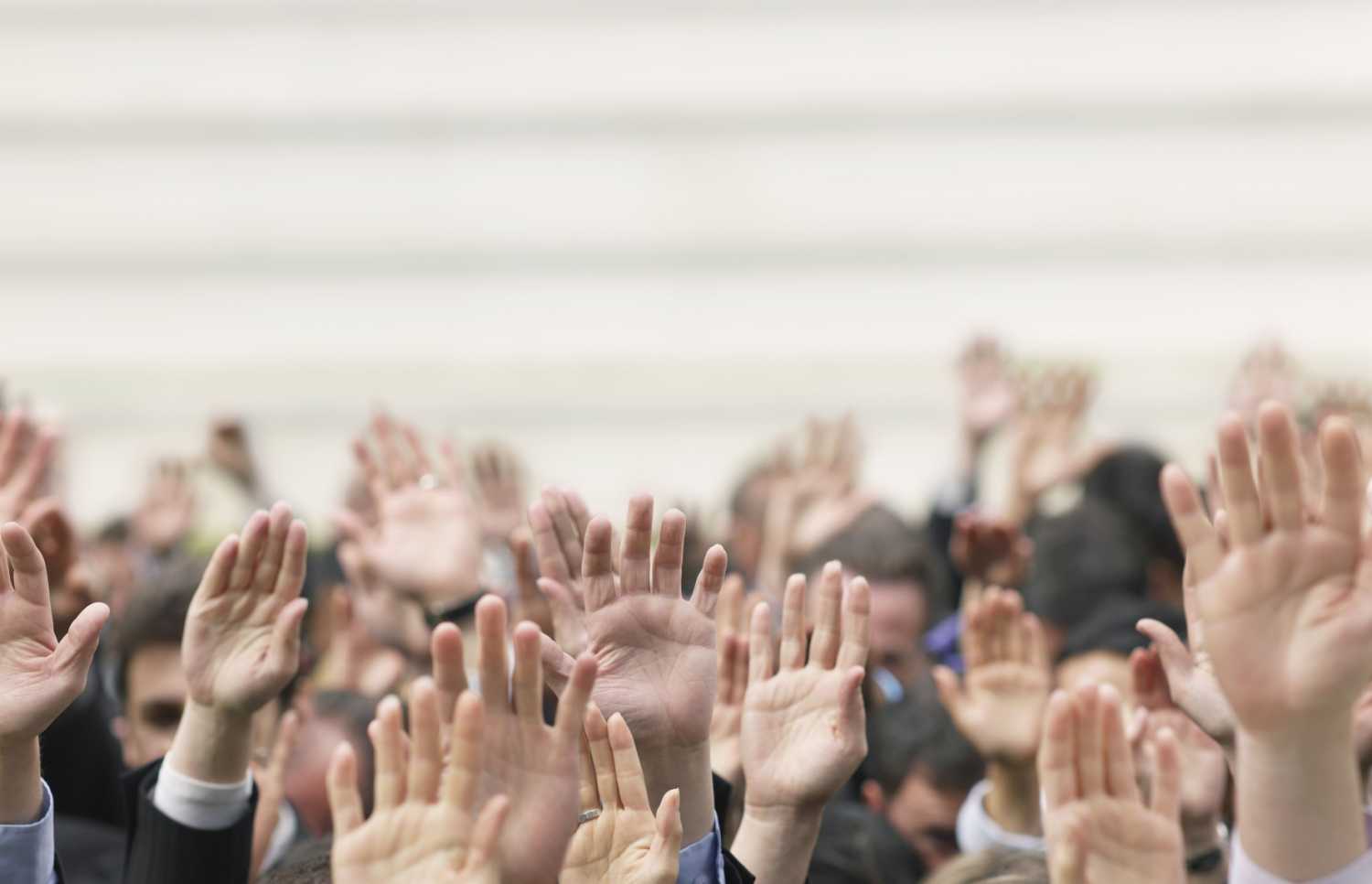 Hands raised in a crowd of people.