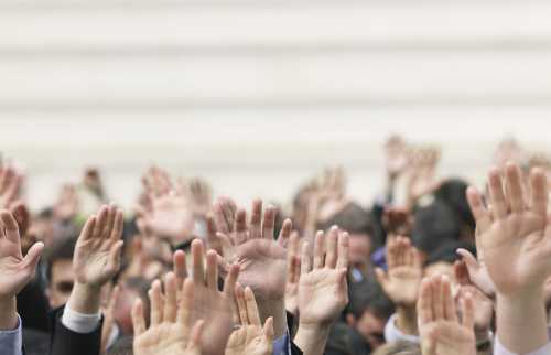 Hands raised in a crowd of people.