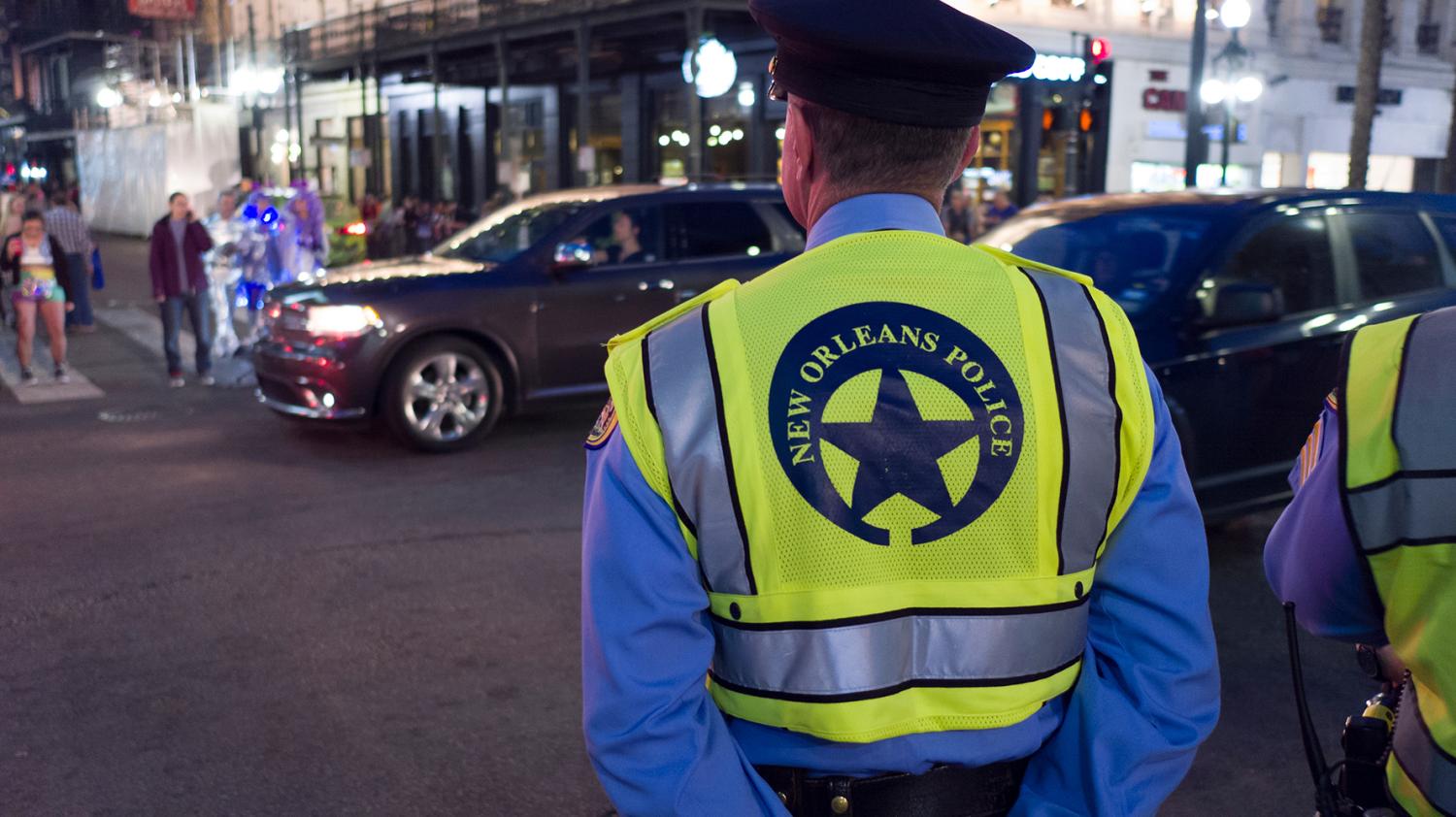 NEW ORLEANS, LOUISIANA - FEBRUARY 9, 2018 - Local police officer standing guard along Hermes Parade route for Mardi Gras celebration on February 9, 2018 in New Orleans, Louisiana.