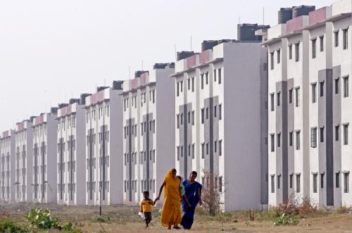 Residents walk past a block of state-funded flats for slum dwellers previously living in low-lying, flood-prone areas in the western Indian city of Surat November 24, 2009.