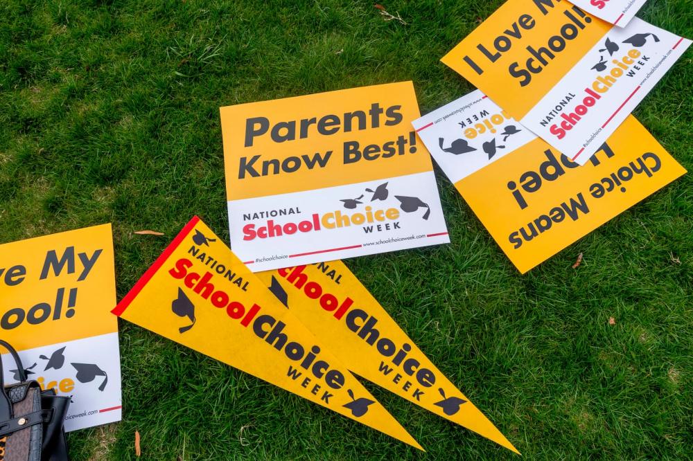 Signs lay in the grass during a rally celebrating National School Choice Week on Halifax Mall in front of the Legislative Building in Raleigh, North Carolina, on Jan. 24, 2024.
