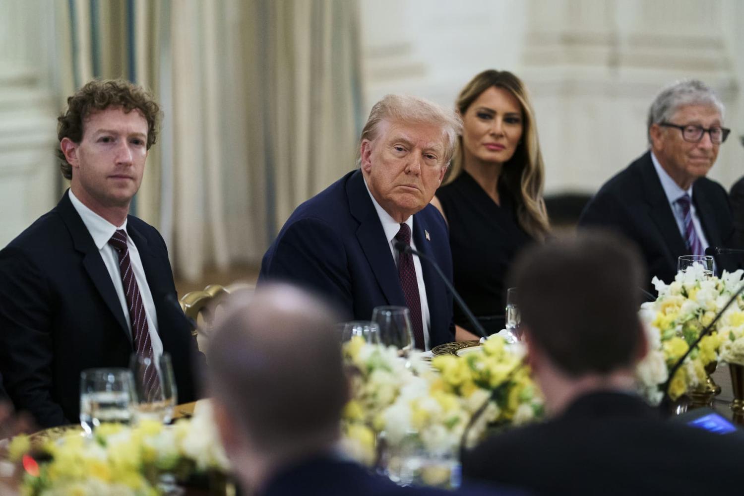 President Donald Trump sits at a table between First Lady Melania Trump, Mark Zuckerburg, and Bill Gates.