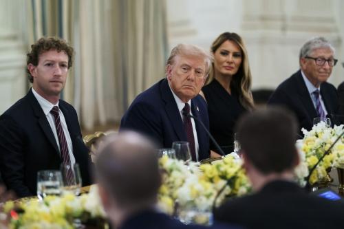 President Donald Trump sits at a table between First Lady Melania Trump, Mark Zuckerburg, and Bill Gates.