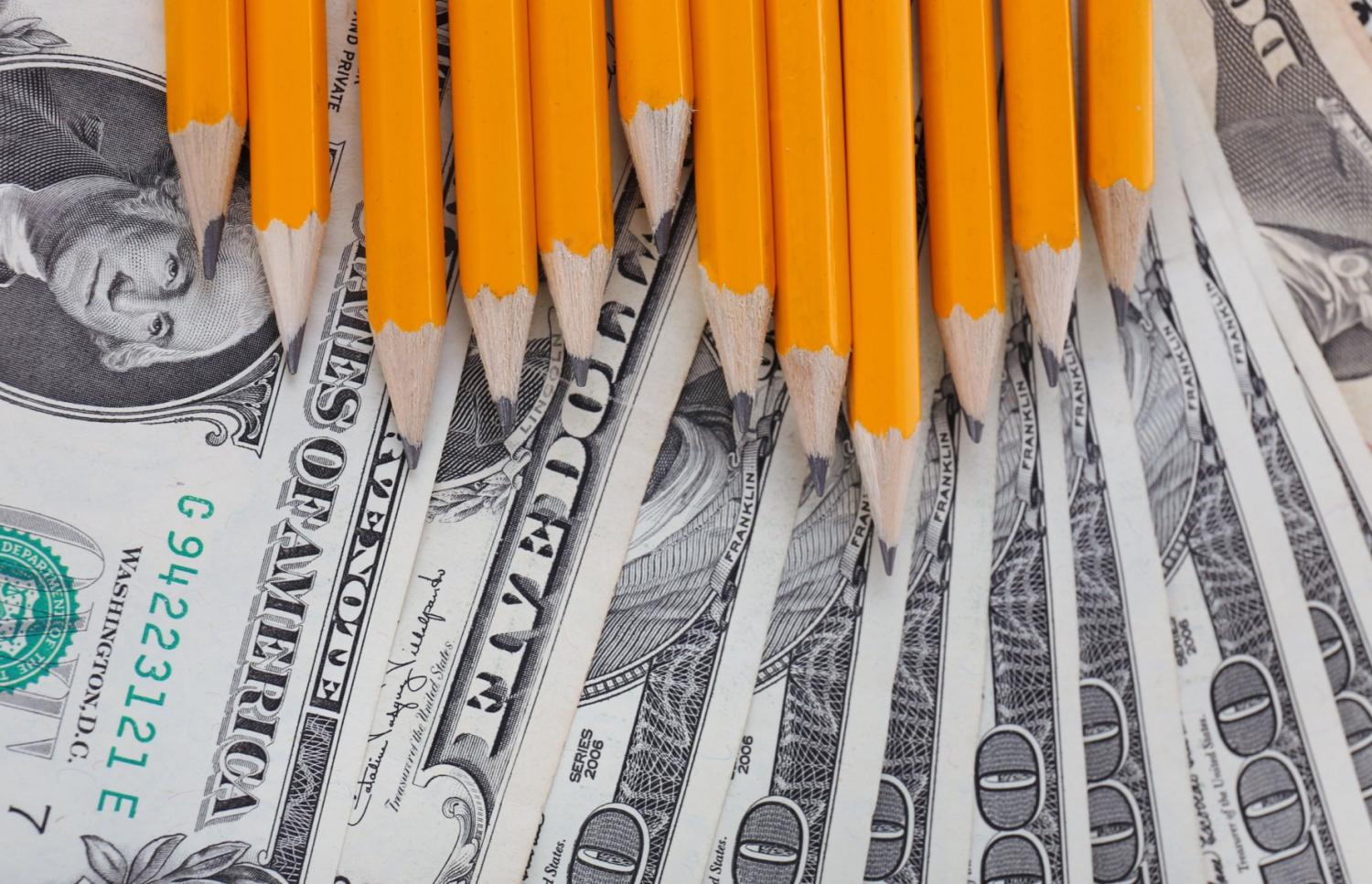 Pencils on top of $100 bills.