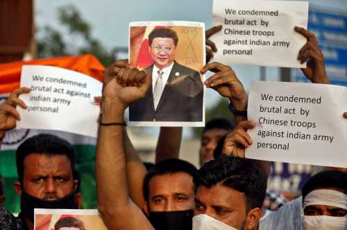 Demonstrators hold placards and a defaced poster of Chinese President Xi Jinping as they shout slogans during a protest against China, in Ahmedabad, India, June 16, 2020.