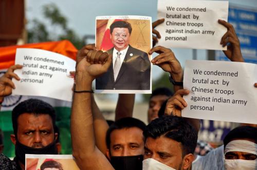 Demonstrators hold placards and a defaced poster of Chinese President Xi Jinping as they shout slogans during a protest against China, in Ahmedabad, India, June 16, 2020.