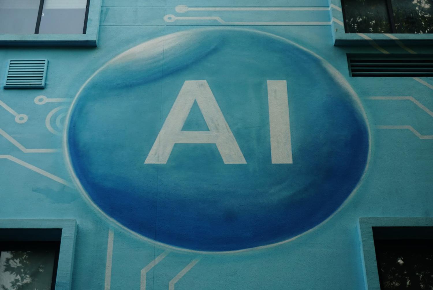 A mural on the side of a building with "AI" written in the center of a blue sphere.