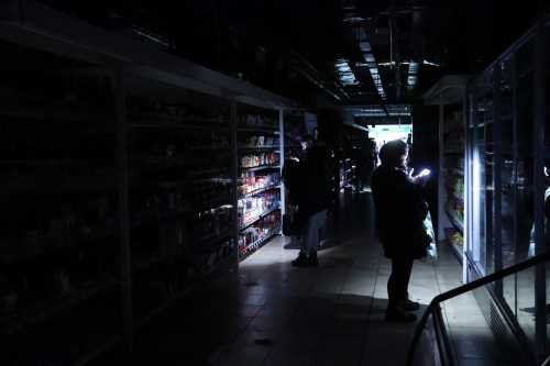 Customers use camera flashes in a supermarket during a power outage in Kyiv, Ukraine, on November 27, 2024.