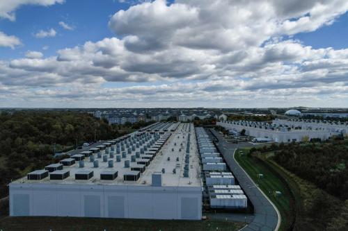 An aerial view of an Amazon Web Services data center with residential areas visible in the background.