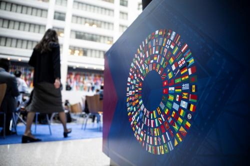 The logo of the IMF-World Bank Annual meetings in the foreground while a woman walks away in the background